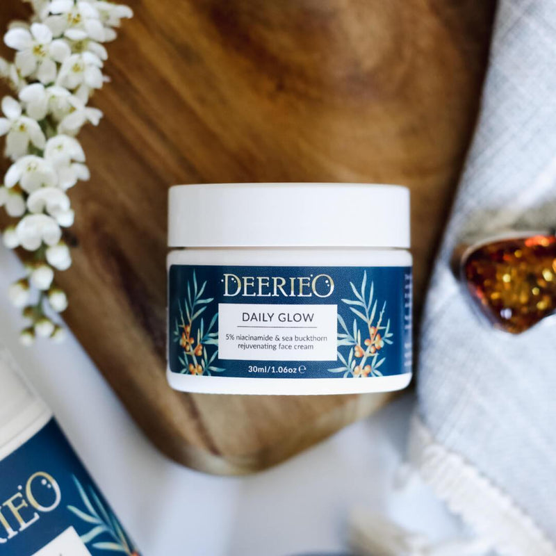 Deerieo Daily Glow Face Cream in a 30 ml white glass jar with navy blue label with sea buckthorn illustration.